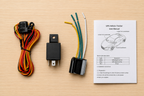 GPS vehicle tracker components with wiring harness and user manual on a wooden surface
